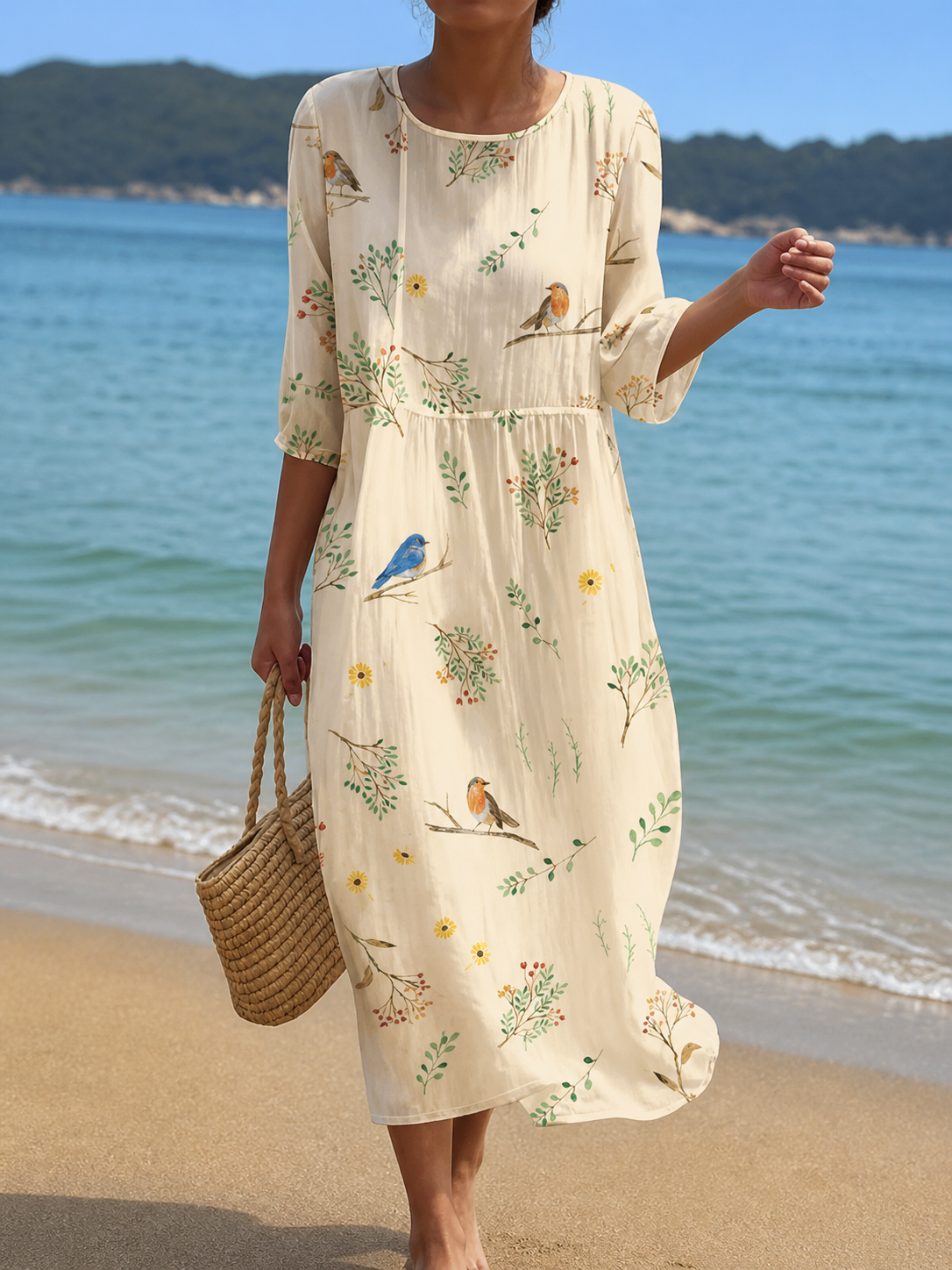 Casual floral print midi dress in cream with bird and sprig print, front view on the beach