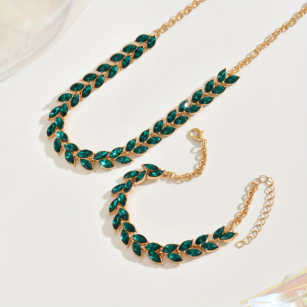Close view of green marquise crystals and gold clasp with chain extender