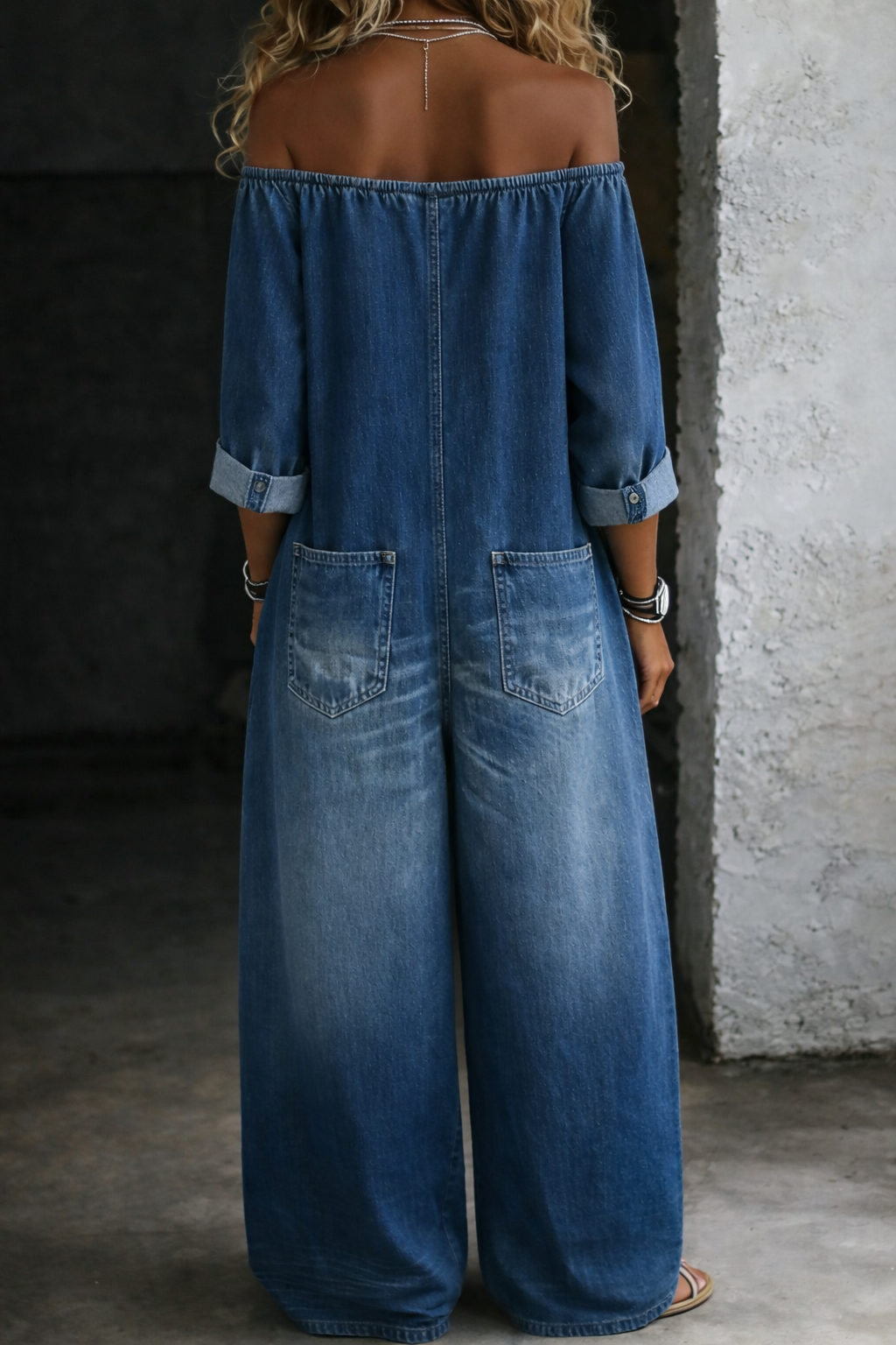 Elena off-shoulder denim jumpsuit in blue, back view with patch pockets
