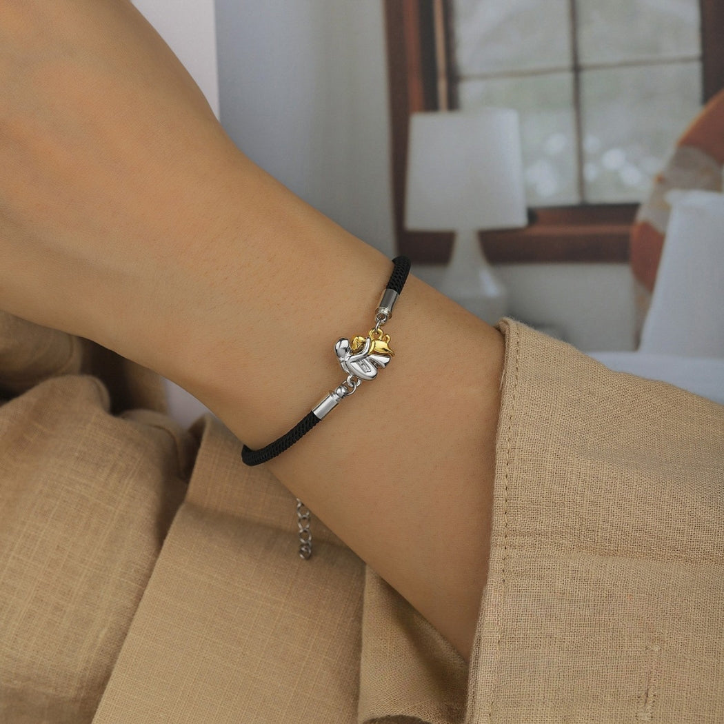 Close-up of black cord bracelet with dog charm on the wrist