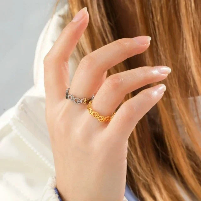 Cat paw rings in silver and gold worn on a model's hand
