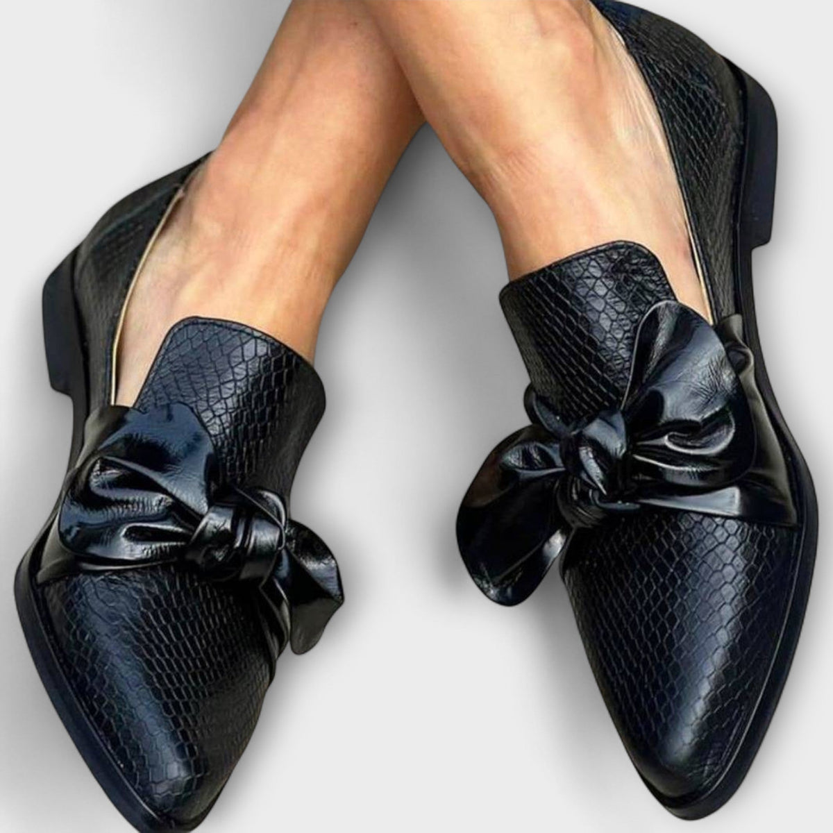 Claudia knot-detail loafers in black, worn front view with pointed toes
