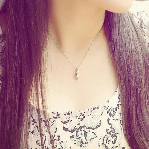 Cat pendant necklace in silver worn at the collarbone, front view
