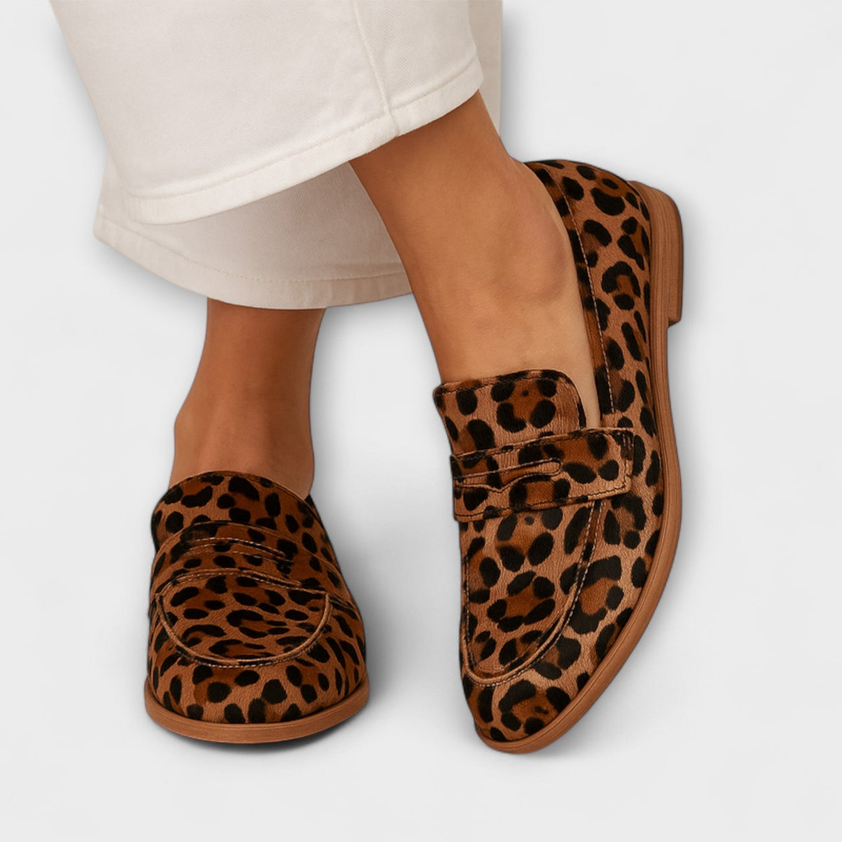 Clara refined loafers in leopard print, worn front view with cream trousers