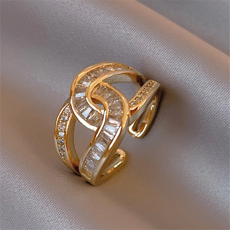 Knotted ring in gold tone with clear stones, close-up view