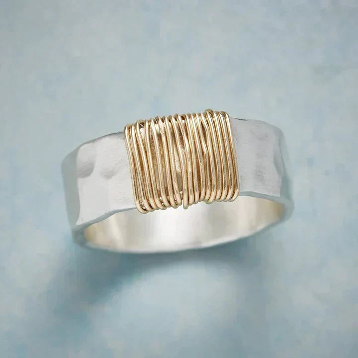 Golden thread silver ring with hammered band and gold wire-wrapped centre, close-up view