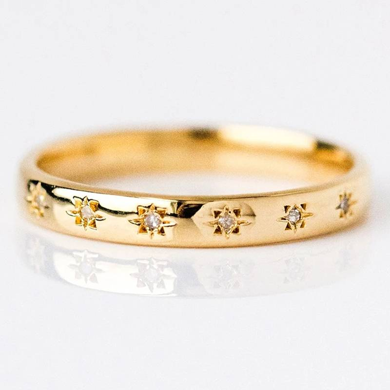 Gold and zirconia ring with star-set stones, close-up side view