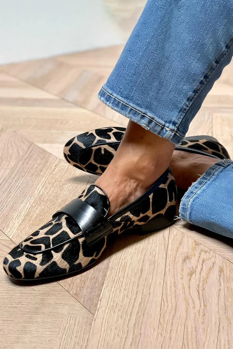 Cow print slip-on loafers in black and beige, worn side view
