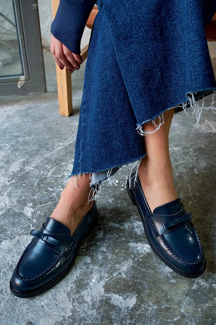 Navy patchwork round-toe loafers with bow, worn with frayed denim