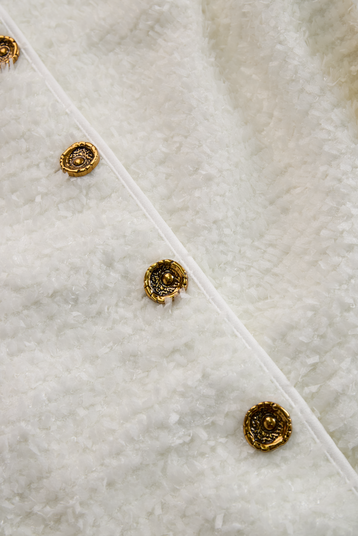 Antigone tweed dress detail, gold-tone button placket close-up