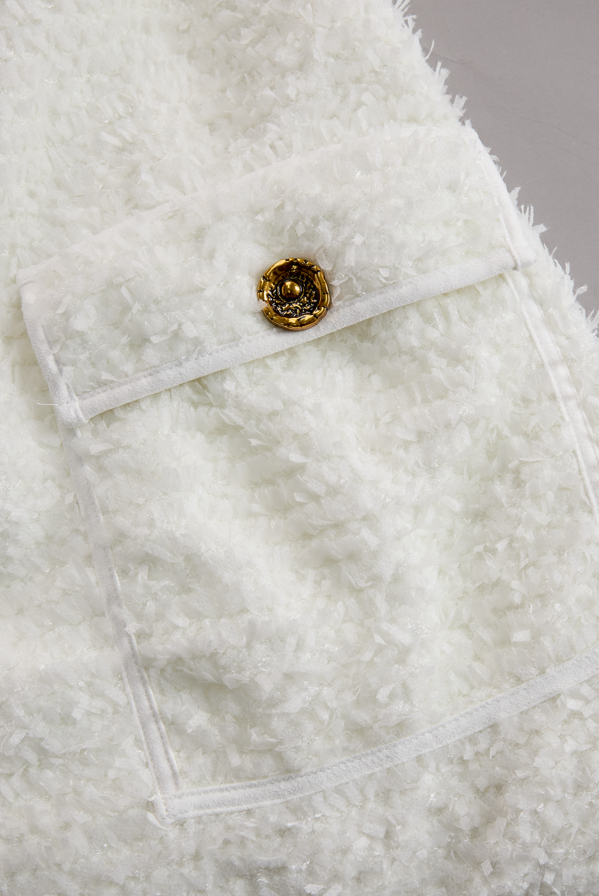 Antigone tweed dress detail, flap hip pocket with gold button