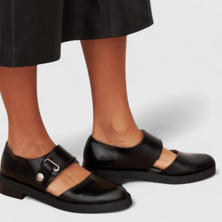 Isla elegant buckled shoes in black, worn side view with midi skirt