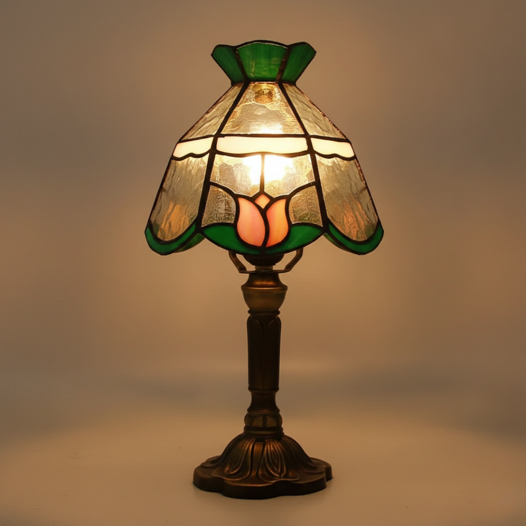 Mysterious Rose stained-glass table lamp with green border and pink tulip motif, lit front view