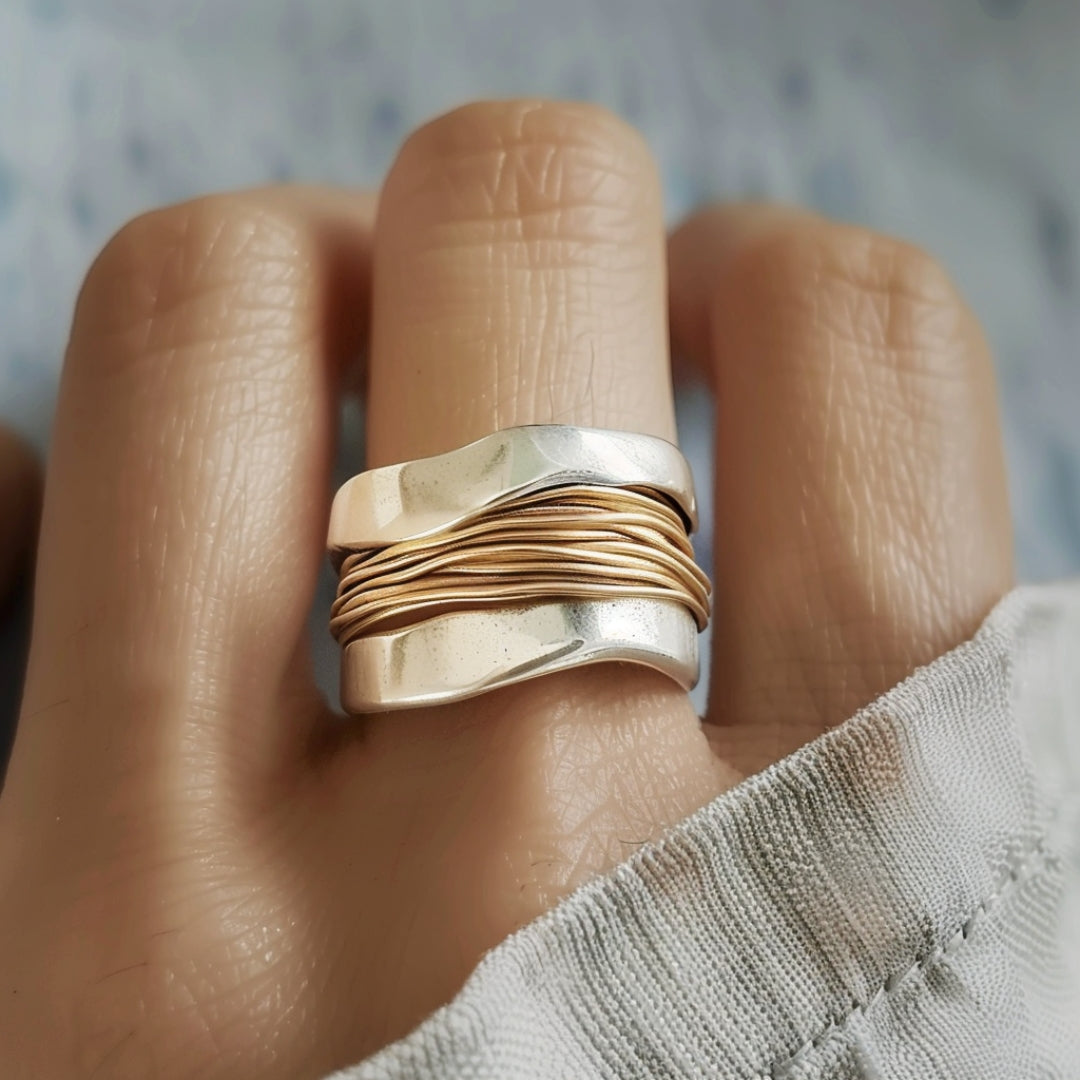 Silver golden threads ring worn on a finger, close-up front view