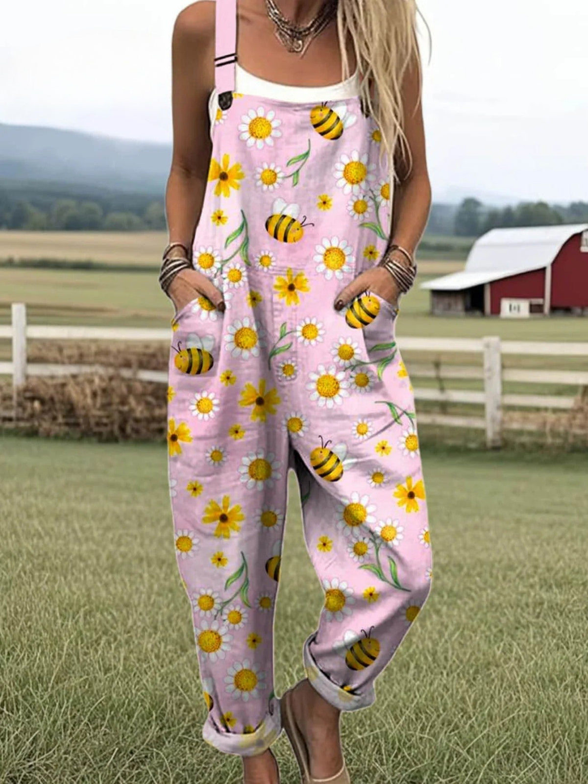Buzz & Bloom dungarees in pink with daisy and bee print, full-length front view