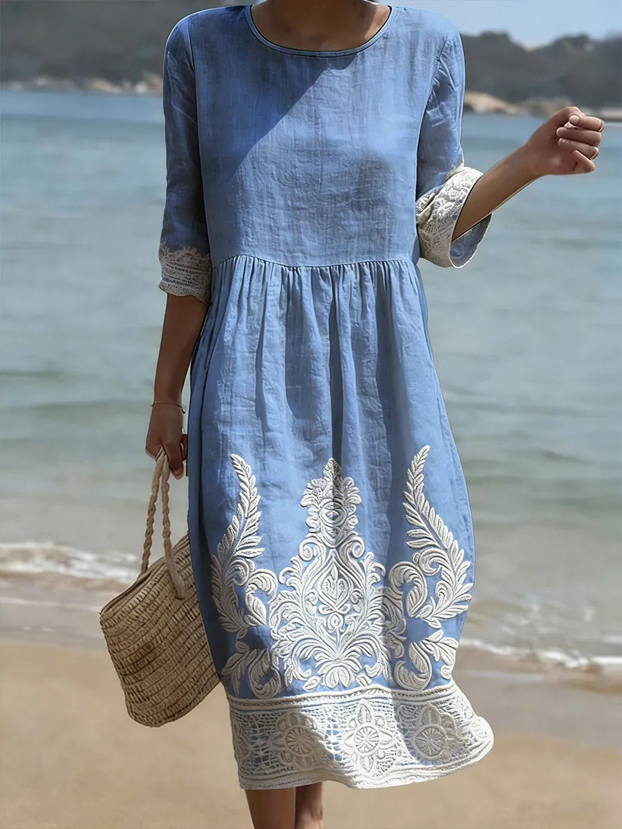 Blue floral print midi dress with cream lace hem, full-length front view on the beach