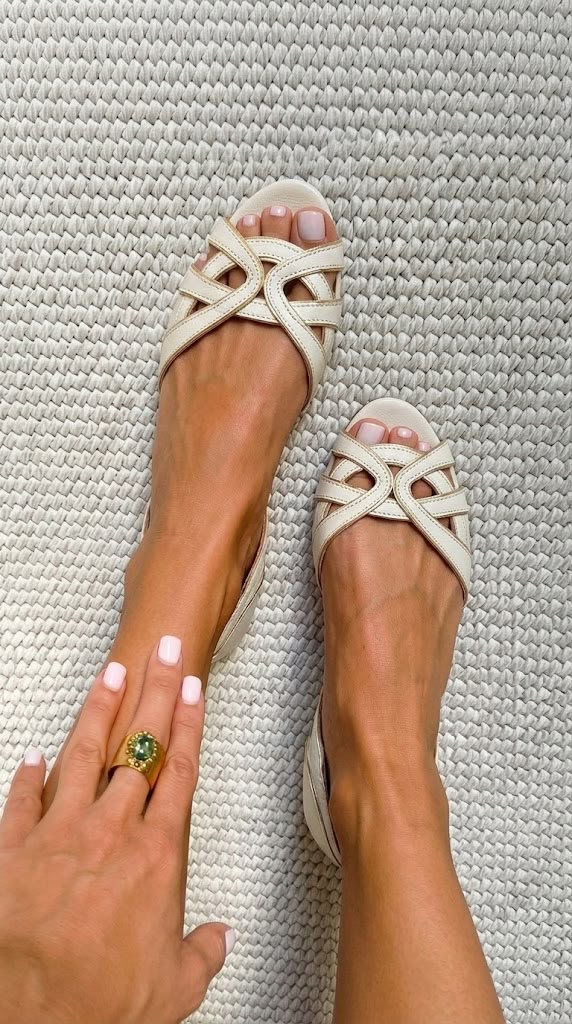 Bella woven flat sandals in cream, top view on textured rug