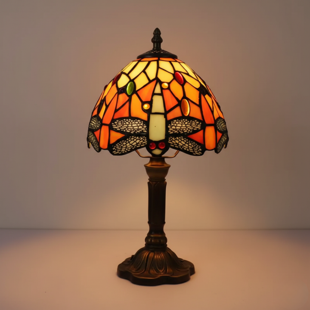 Dragonfly stained-glass table lamp in amber and orange, lit front view
