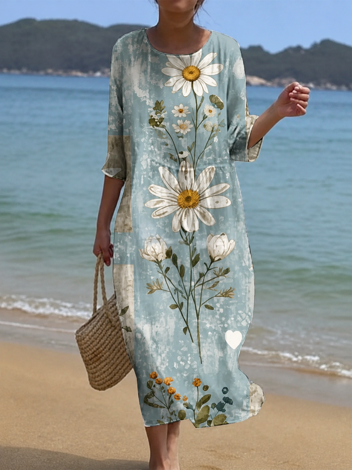 Casual floral print midi dress in soft blue-green with daisy print, front view on the beach
