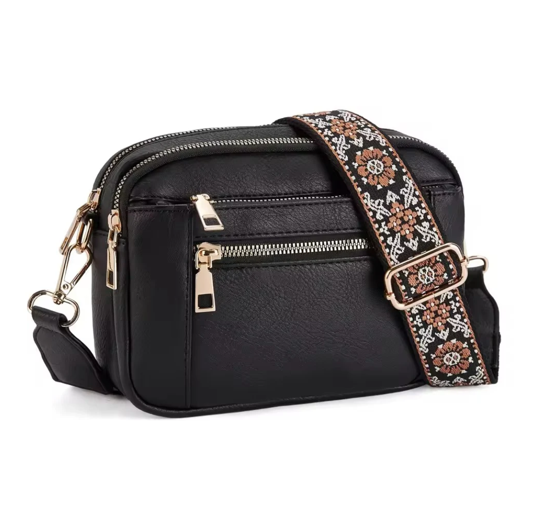 Strap crossbody bag in black with patterned woven strap