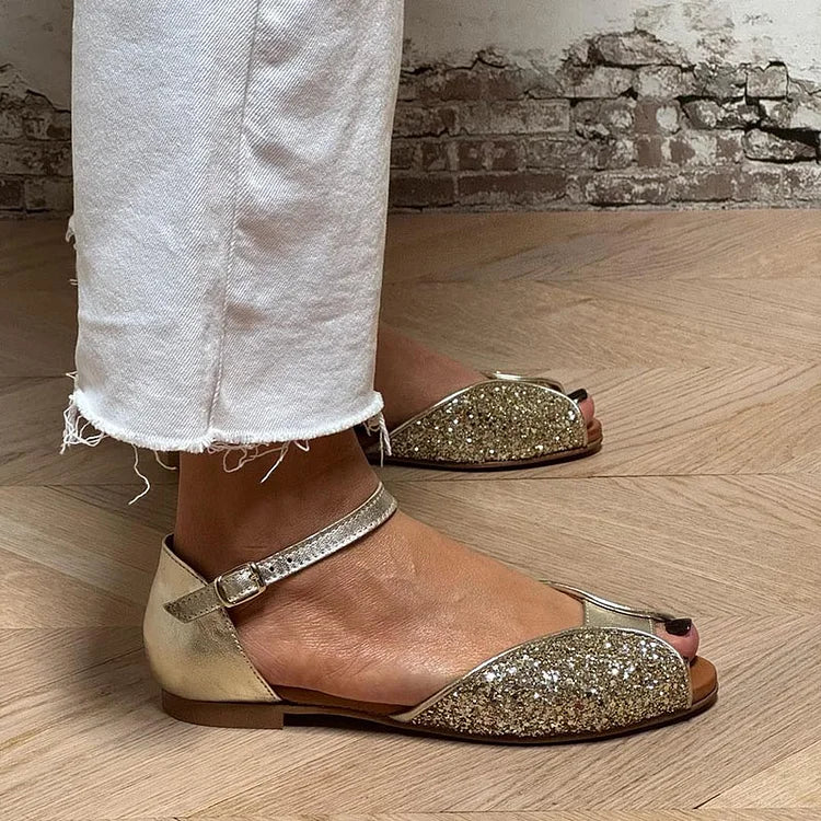 Gold glitter flat sandals worn with white cropped jeans, side view