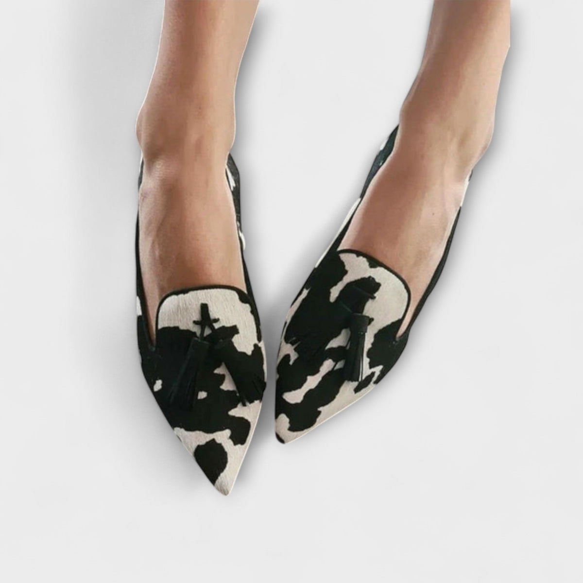 Lucia pointed loafers in black and cream print with black tassels, worn view