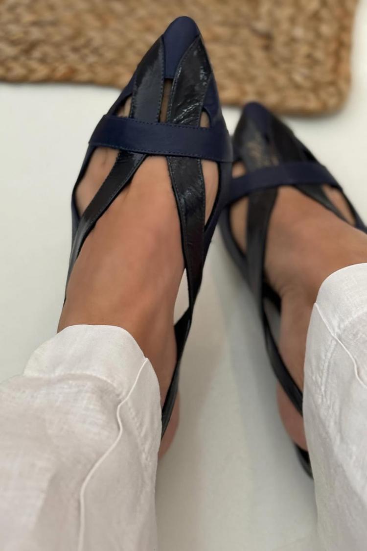Navy slingback pointed-toe flats worn, angled top view