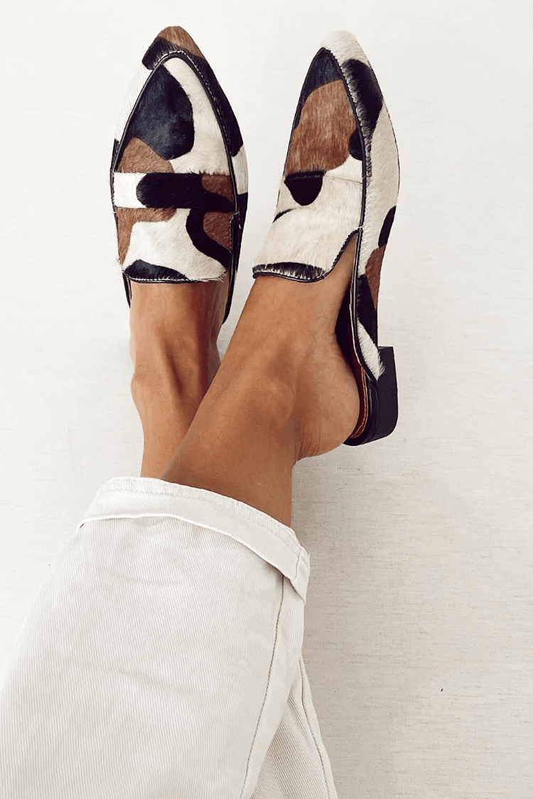 Round-toe patchwork loafers in cream, brown and black animal print, worn with white trousers