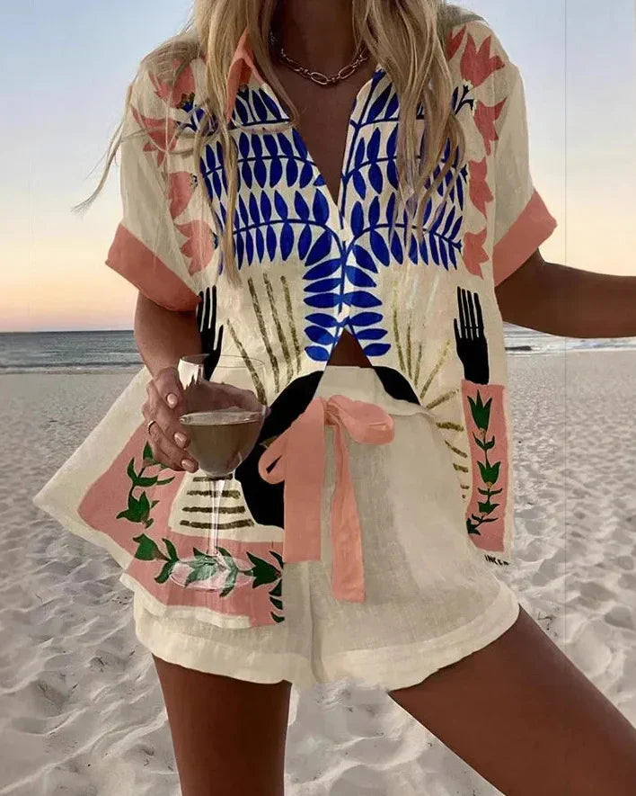 Azure summer co-ord set in cream with blue and pink print, front view on beach