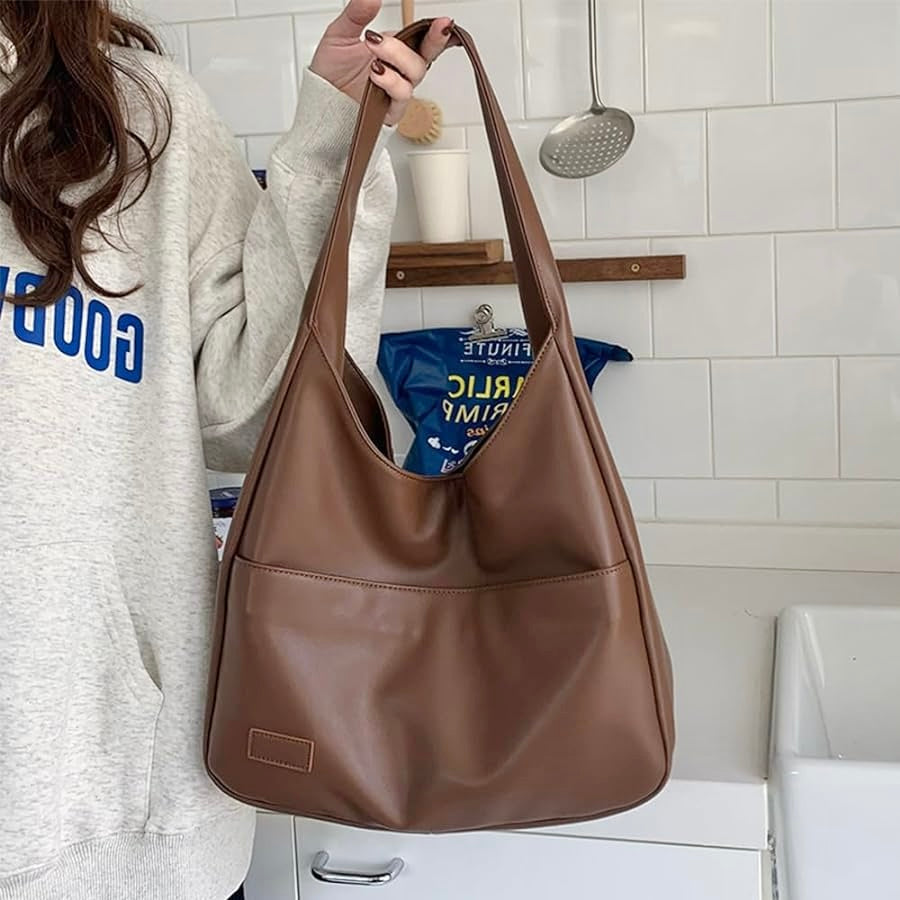 Fiora bag in brown held by hand, close-up of open top