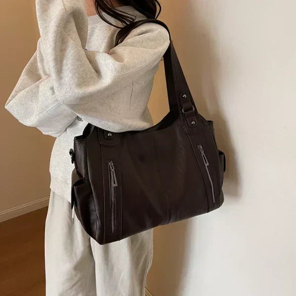 Rae handbag in dark brown worn over the shoulder, side view