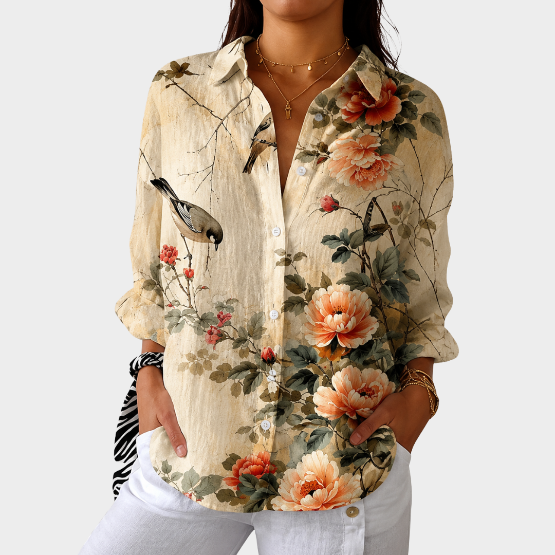 Flowy printed blouse in cream floral bird print, front view with white trousers
