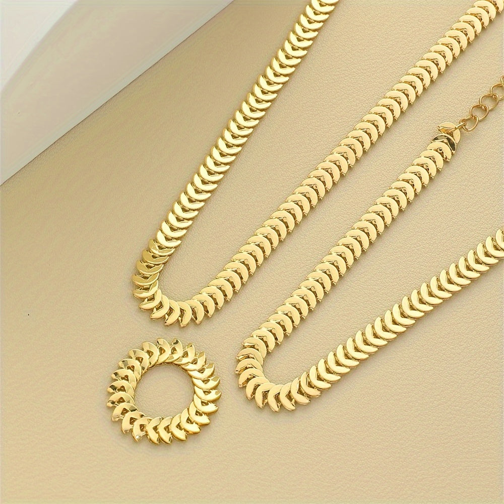 Close-up flat lay of gold chevron-link necklace, bracelet and ring