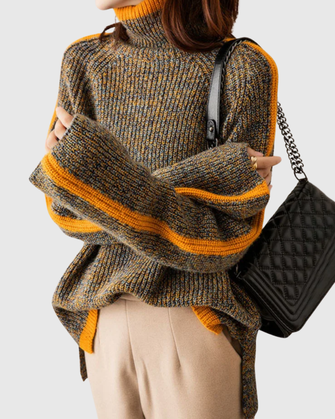 Thalira turtleneck sweater in grey-yellow marl, worn with beige trousers, front view