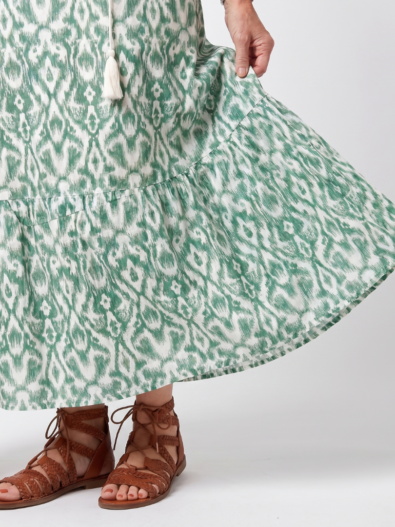 Close-up of the tiered hem and green print on the Ilara midi dress