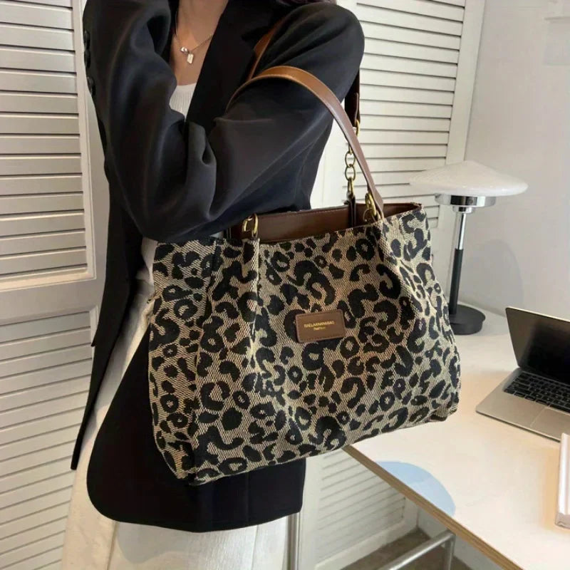 Tavira leopard tote bag carried at a desk with a black blazer