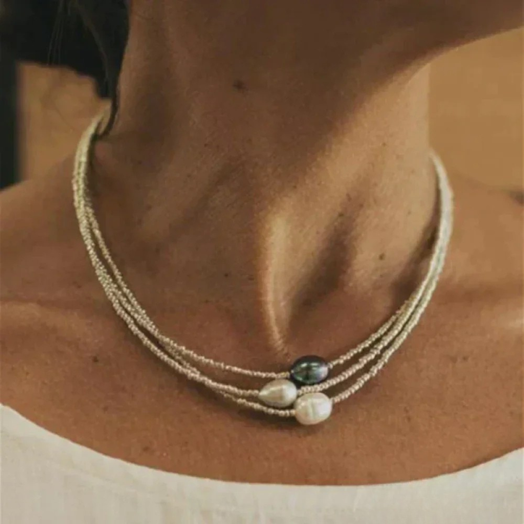 Eternal Elegance pearl necklace in pale gold with three centre pearls, worn close-up