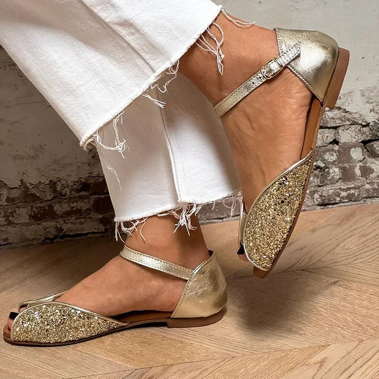 Gold glitter peep-toe sandals with buckled ankle strap, angled worn view