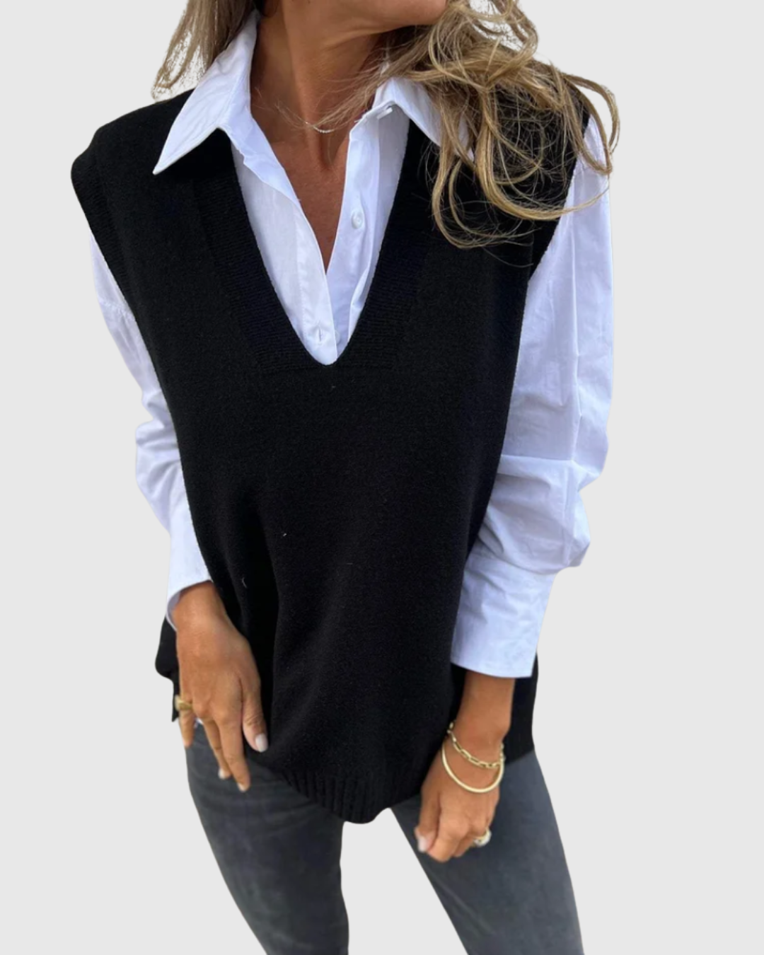 Nerelis knit sweater vest in black, layered over a white shirt, front view