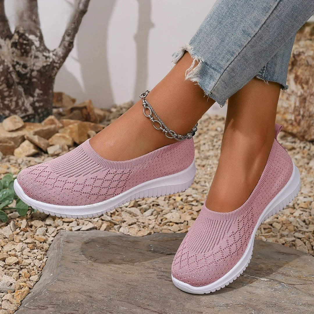 Estella slip-on shoes in pink, worn outdoors, angled view