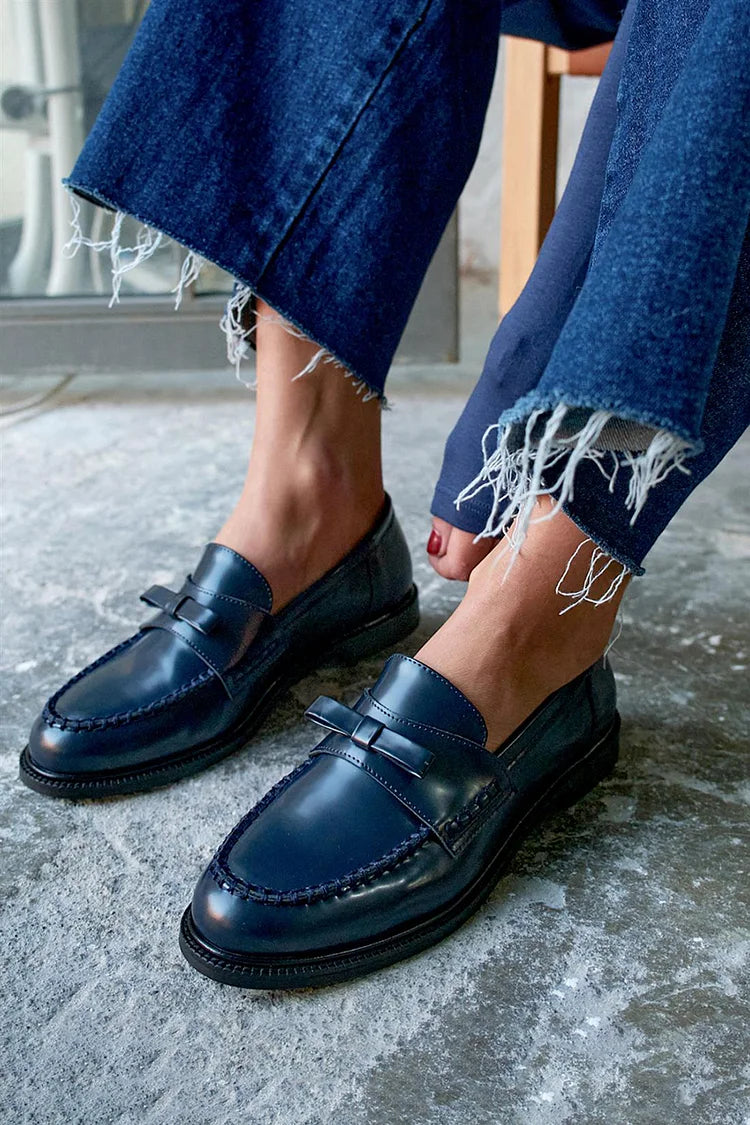 Navy round-toe loafers side view, showing low heel and dark sole