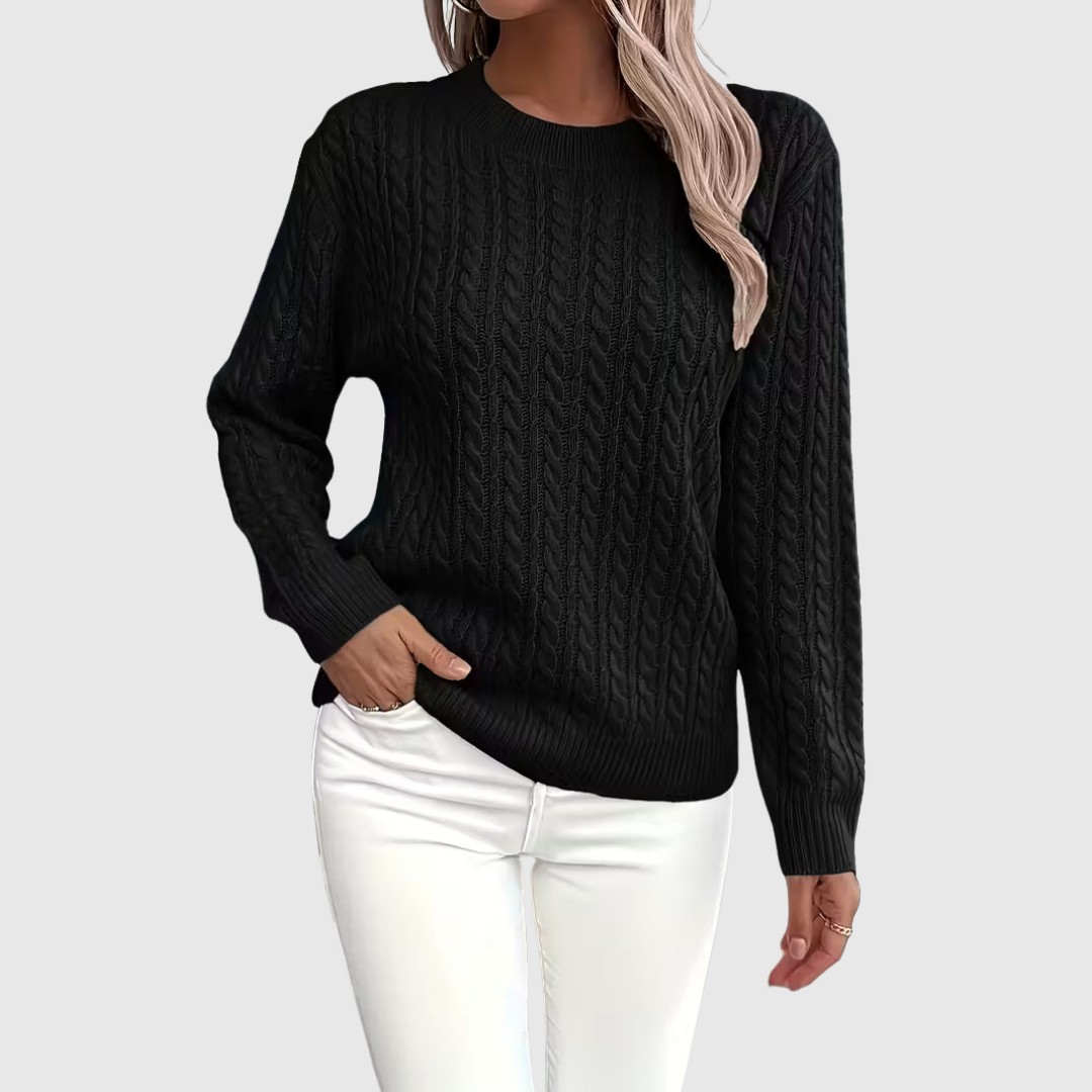 Isla cable-knit sweater in black, front view with white jeans