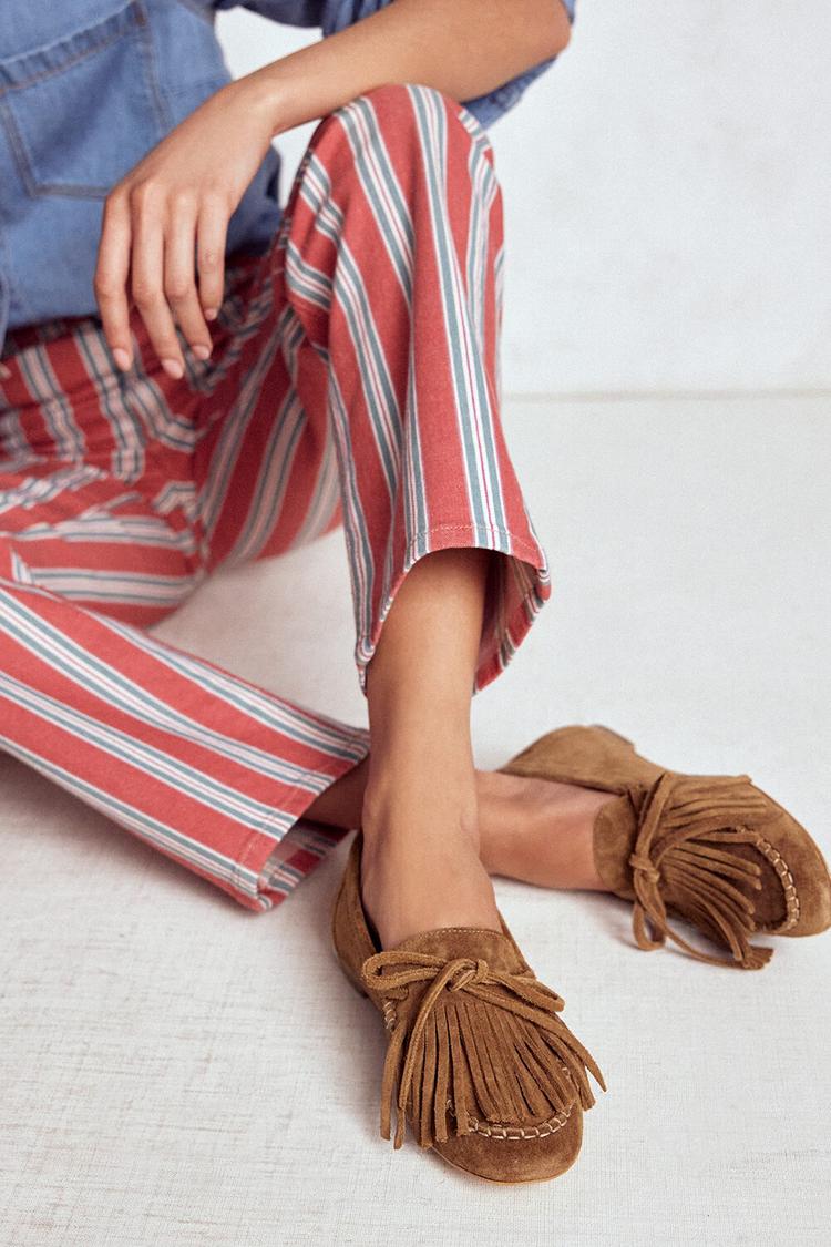 Camel loafers with fringe and tie detail, close view on seated model