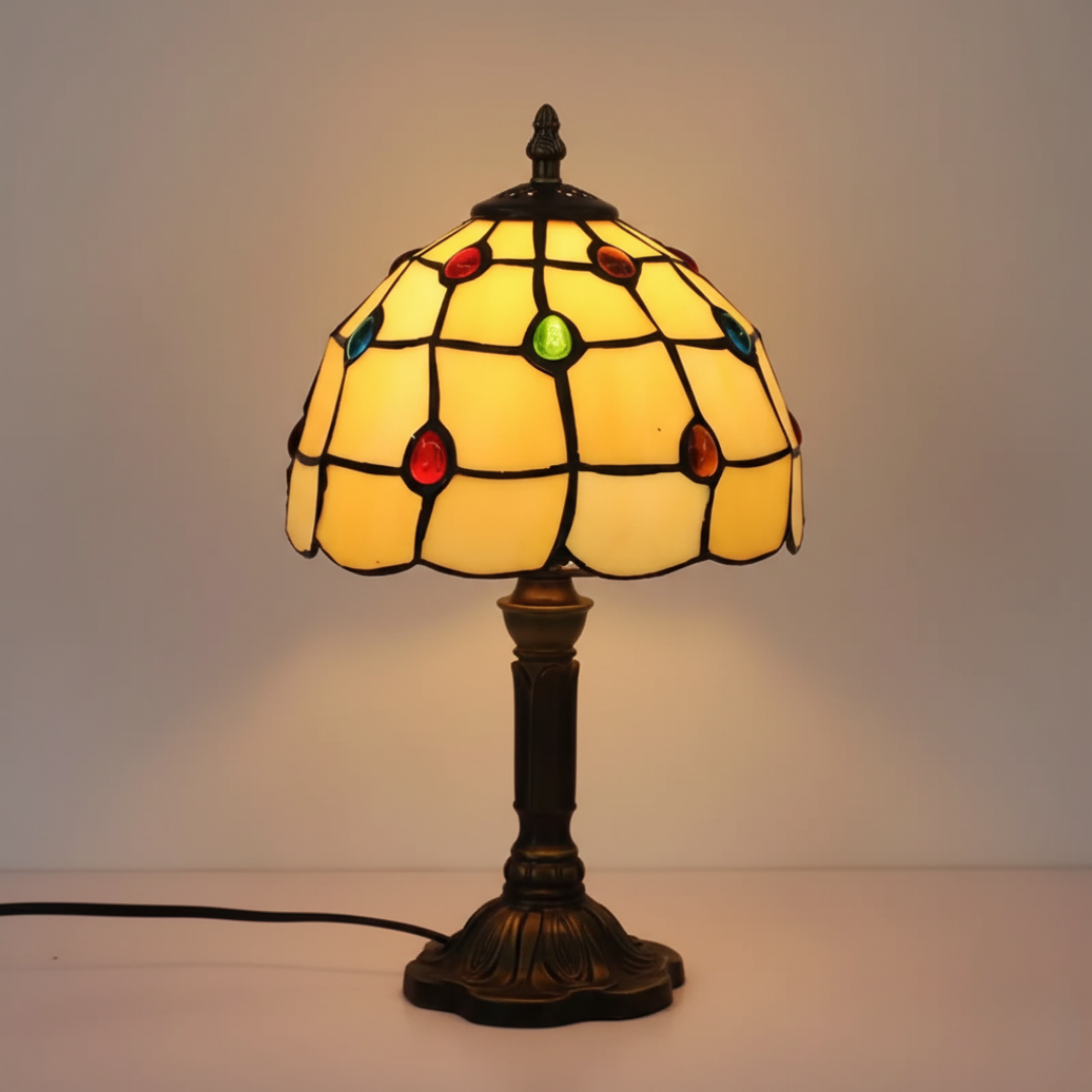 Golden Diamonds stained-glass table lamp with cream panels and bronze base, lit