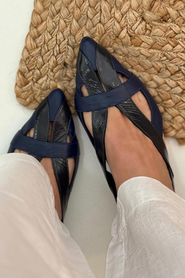 Navy patchwork ballet flats worn with white trousers, overhead view