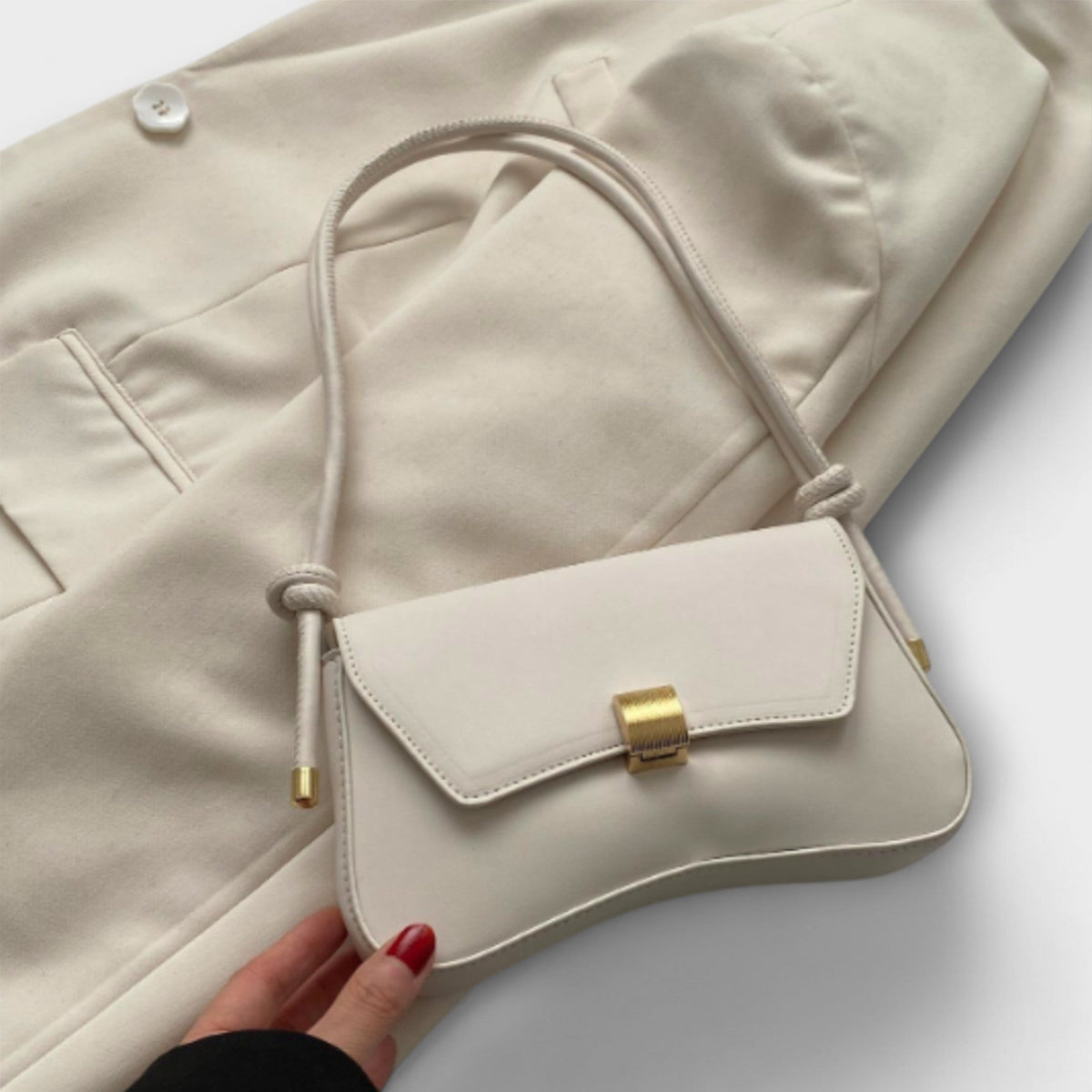 Cécile mini shoulder bag in cream with gold clasp, front view