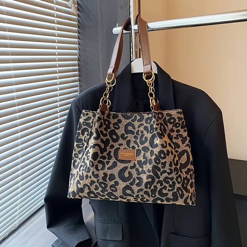 Classic leopard tote bag hanging beside a black blazer, front view