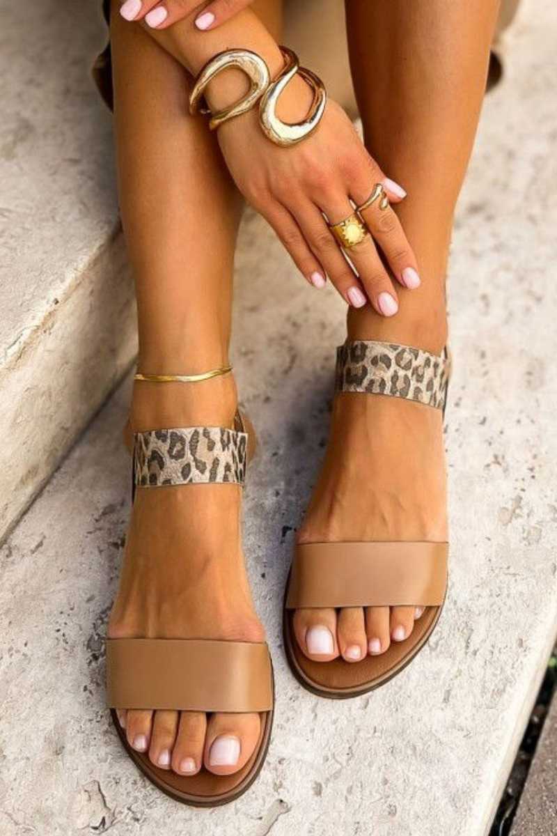 Leopard print low sandals in tan, worn on steps, front view