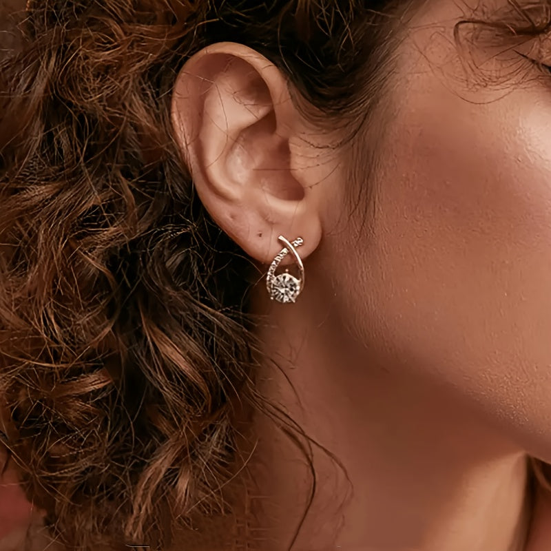 Leni gold zirconia earring worn on the earlobe, side view