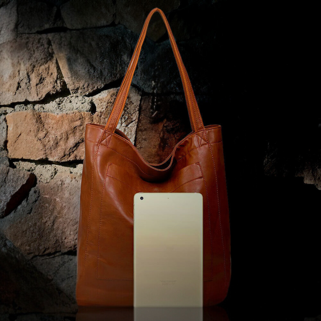 Maisie urban handbag in brown shown upright with tablet beside it